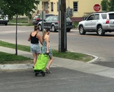 Users cross a street with green shopping trolley